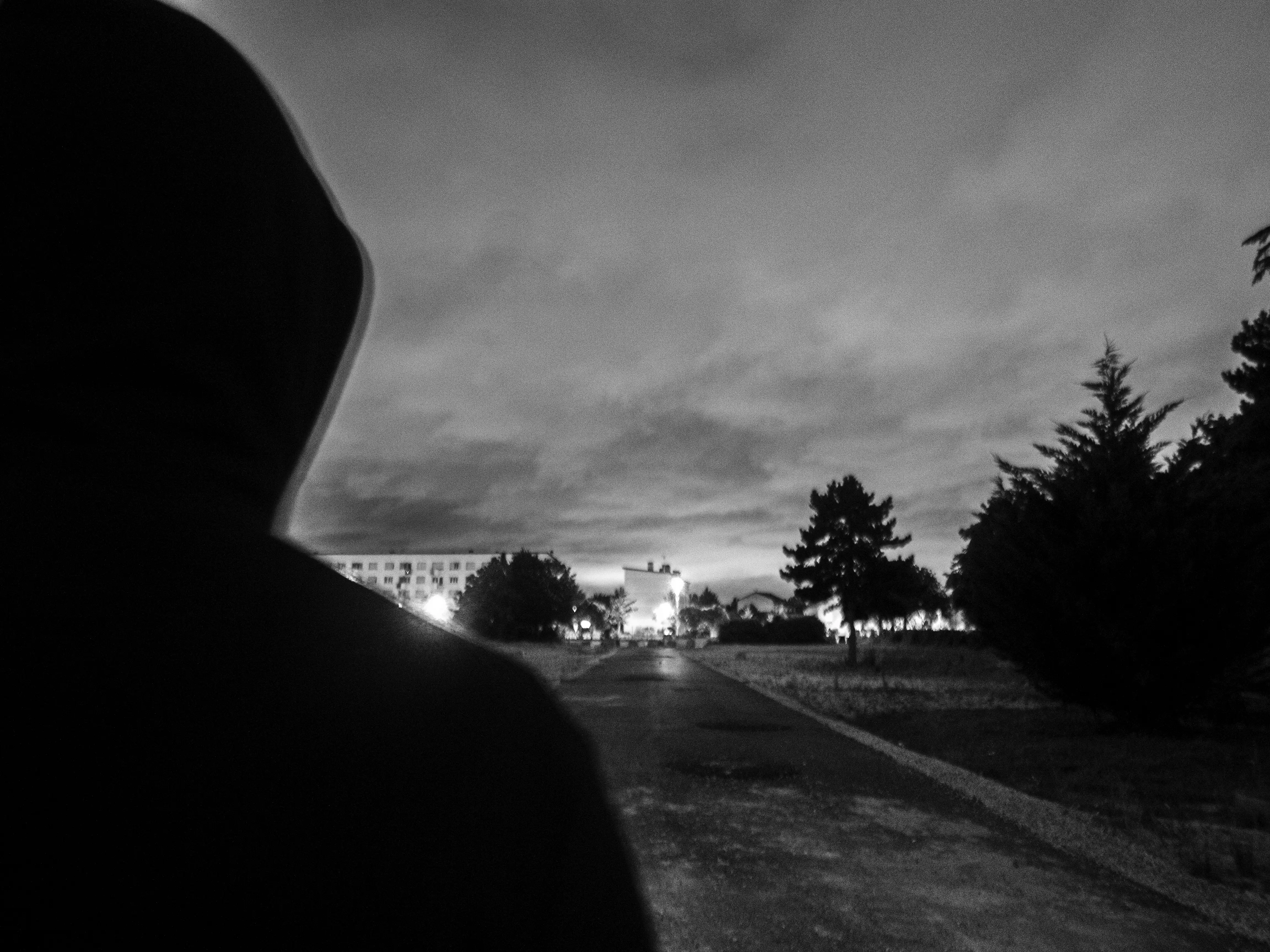 Capuche relevée. La cité en face.